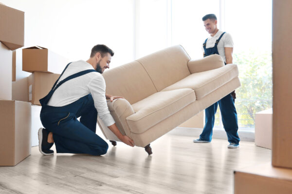Delivery,Men,Moving,Sofa,In,Room,At,New,Home